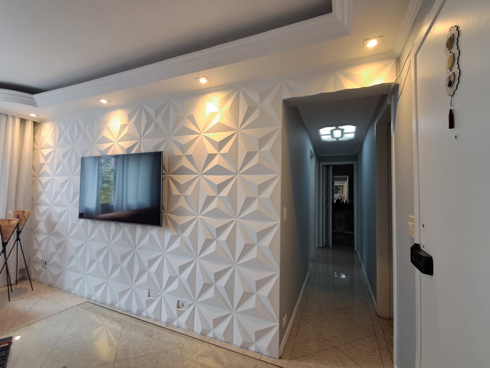 Sala bem conservada com painel planejado e iluminação embutida